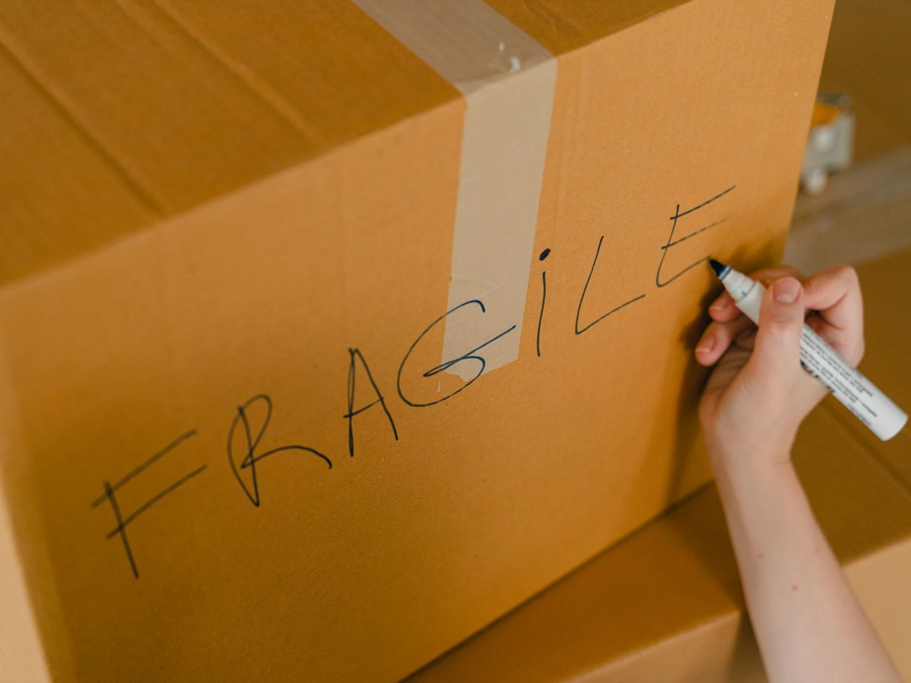 Hand beschriftet einen Karton für den Versand